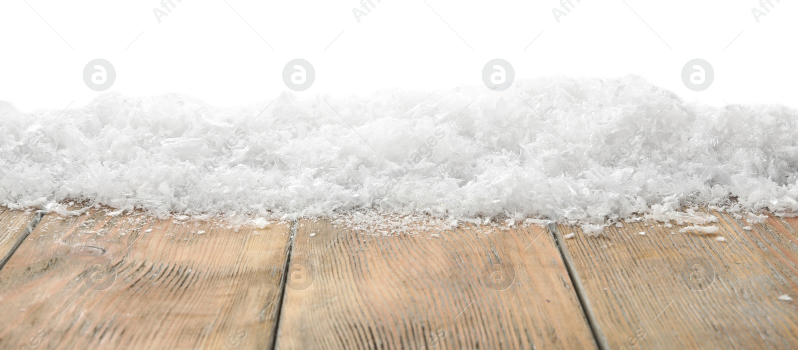 Photo of Snow on wooden surface against white background. Christmas season