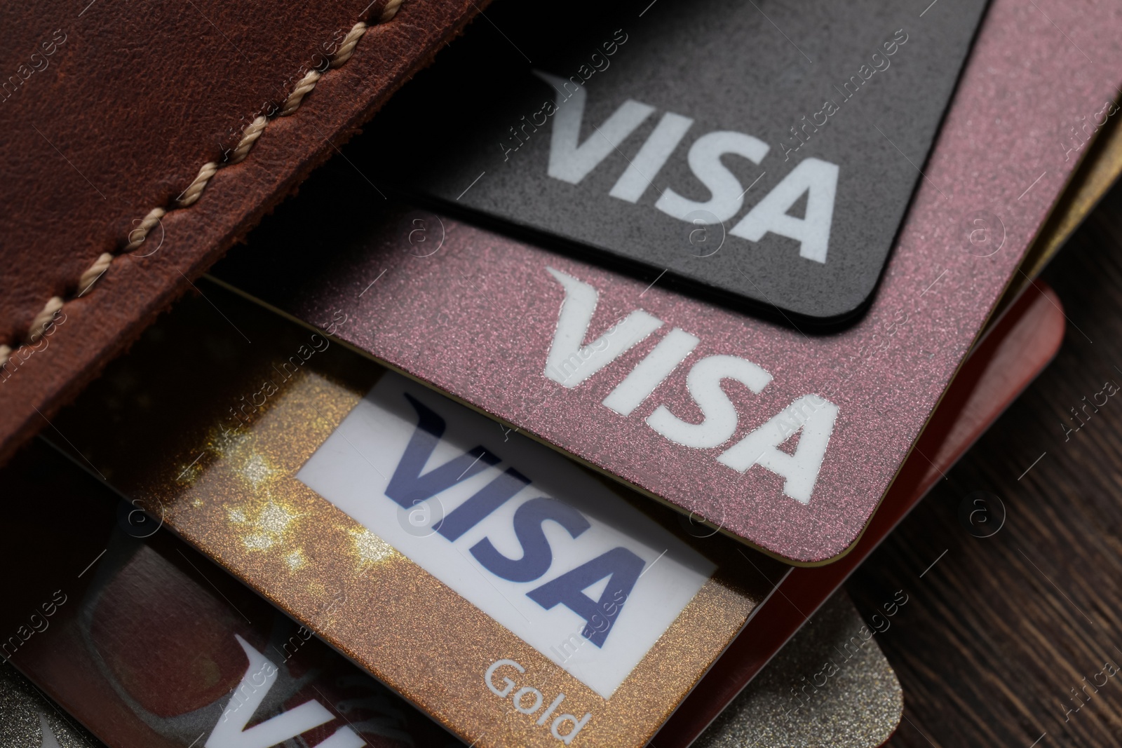 Photo of MYKOLAIV, UKRAINE - FEBRUARY 22, 2022: Wallet with Visa credit cards on wooden table, closeup