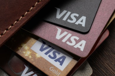 MYKOLAIV, UKRAINE - FEBRUARY 22, 2022: Wallet with Visa credit cards on wooden table, closeup