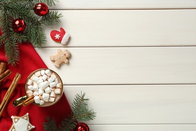 Delicious hot chocolate with marshmallows near cookies and Christmas decor on white wooden table, flat lay. Space for text