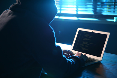 Hacker with laptop in dark room. Cyber crime