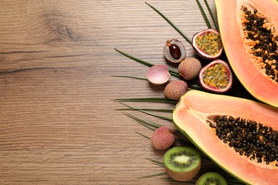 Fresh ripe papaya and other fruits on wooden table, flat lay. Space for text