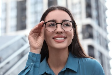 Portrait of beautiful woman in glasses outdoors. Attractive lady smiling and posing for camera