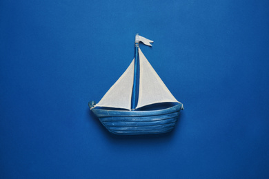 Photo of Toy ship on bright background, top view. Color of the year 2020 (Classic blue)