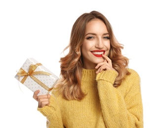 Happy young woman with Christmas gift on white background