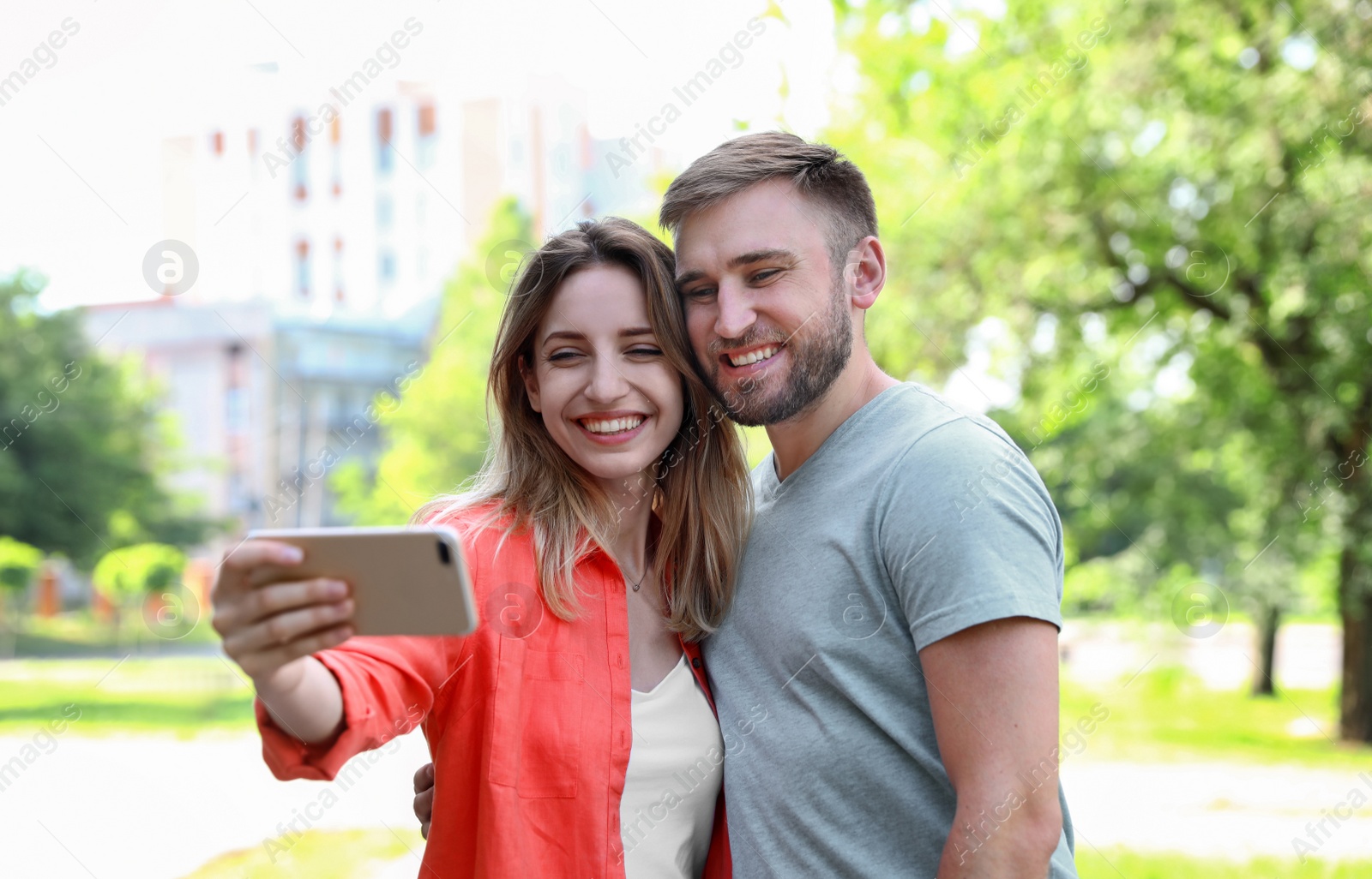 Photo of Happy young couple taking selfie in park