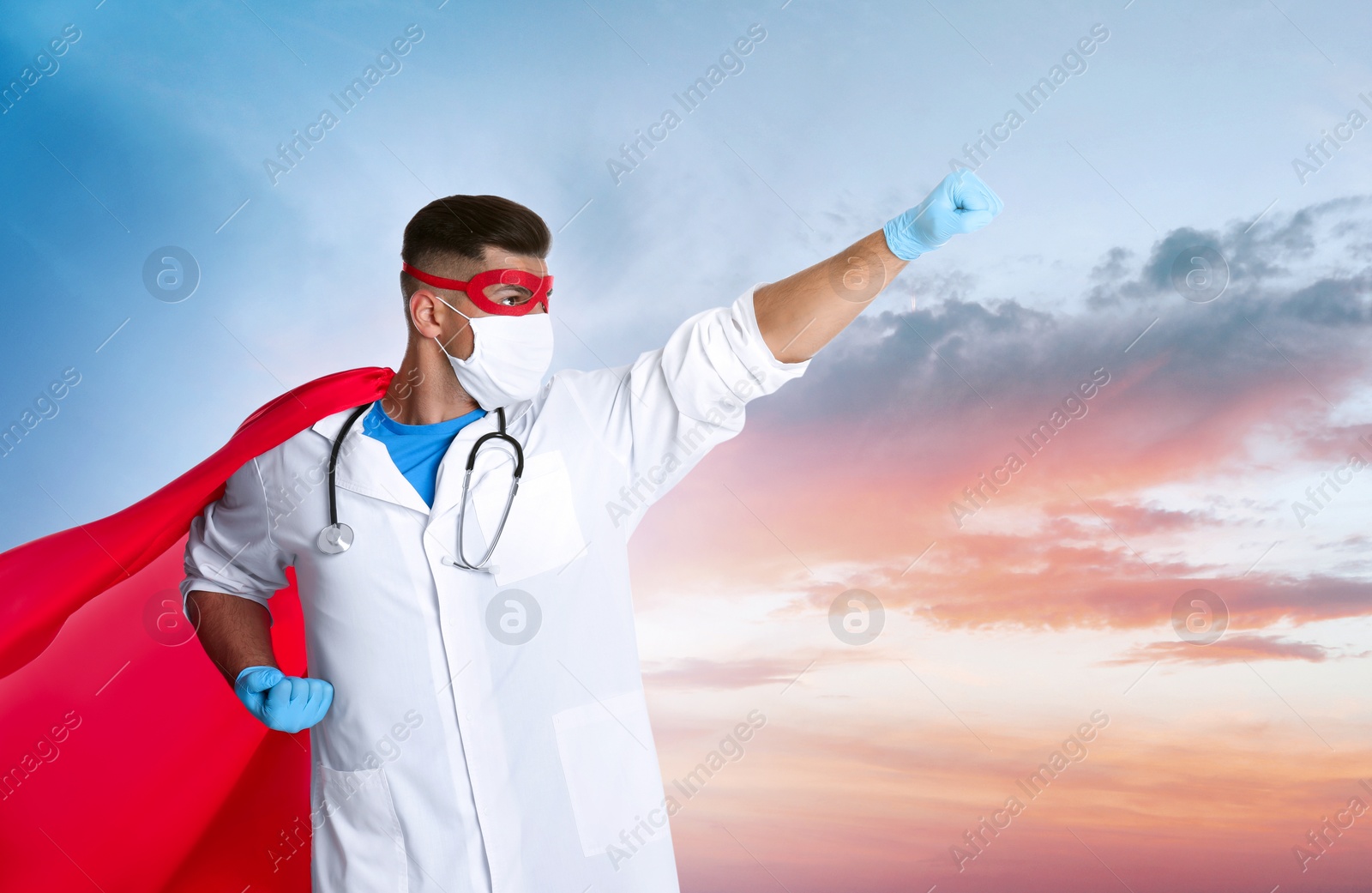 Image of Doctor wearing face mask and superhero costume against sky with clouds, space for text