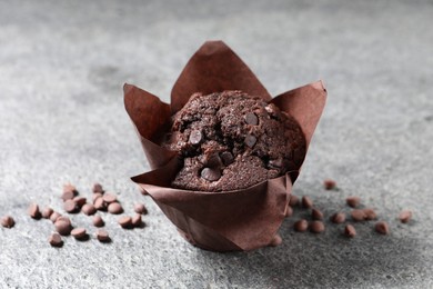 Photo of Tasty chocolate muffin on grey table, closeup