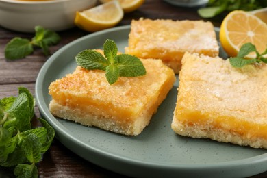 Photo of Tasty lemon bars and mint on table, closeup