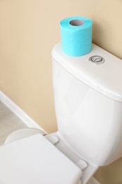 Paper roll on toilet tank in bathroom