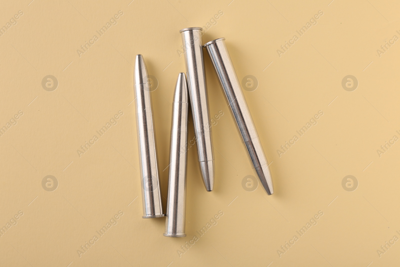 Photo of Many metal bullets on yellow background, flat lay