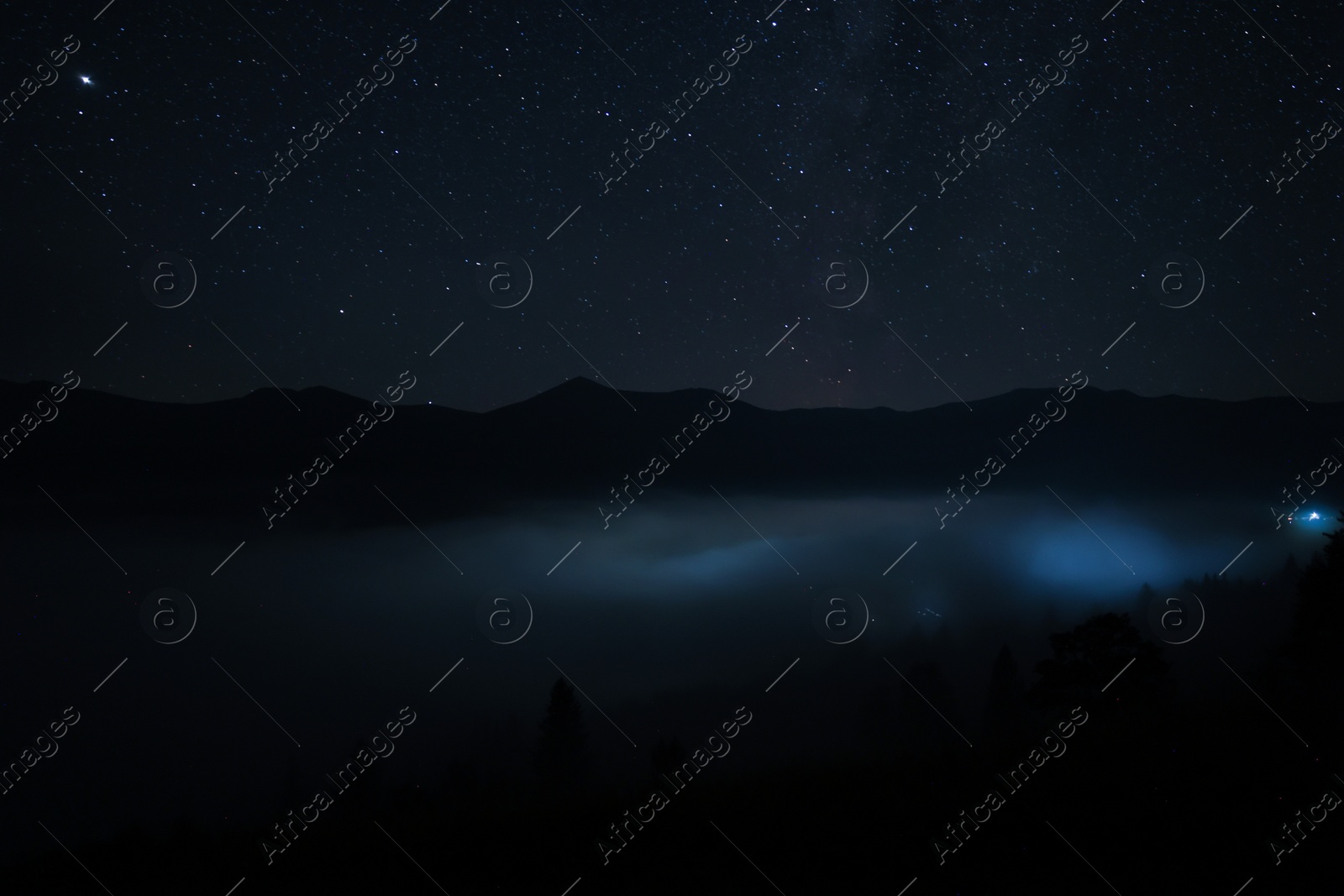 Photo of Beautiful view of misty mountains under starry sky at night