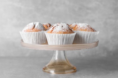 Photo of Cake stand with tasty muffins on light grey table