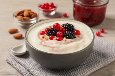 Photo of Delicious semolina pudding with berries on wooden table