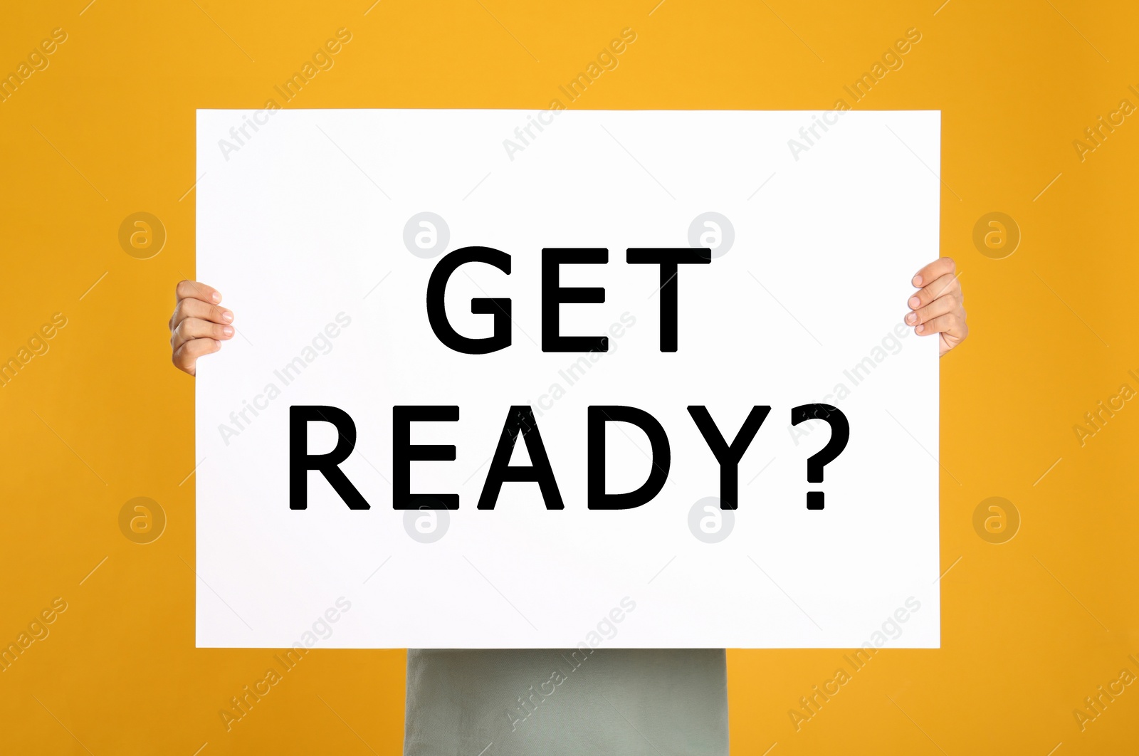 Image of Man holding poster with text Get Ready? on yellow background 