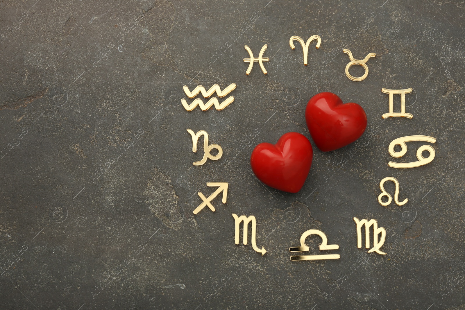 Photo of Zodiac signs and red hearts on grey textured background, flat lay. Space for text