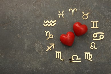 Photo of Zodiac signs and red hearts on grey textured background, flat lay. Space for text