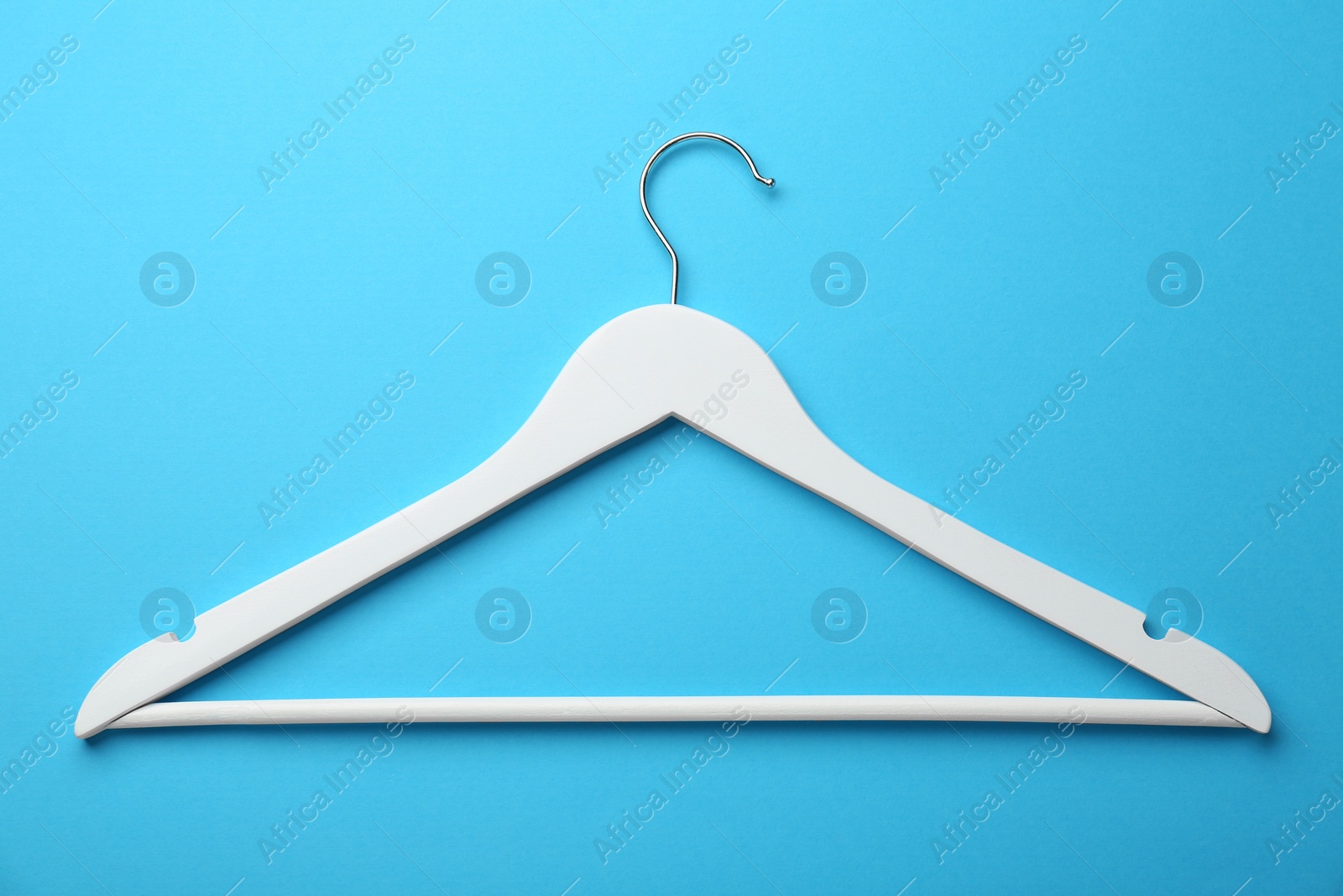 Photo of White hanger on light blue background, top view