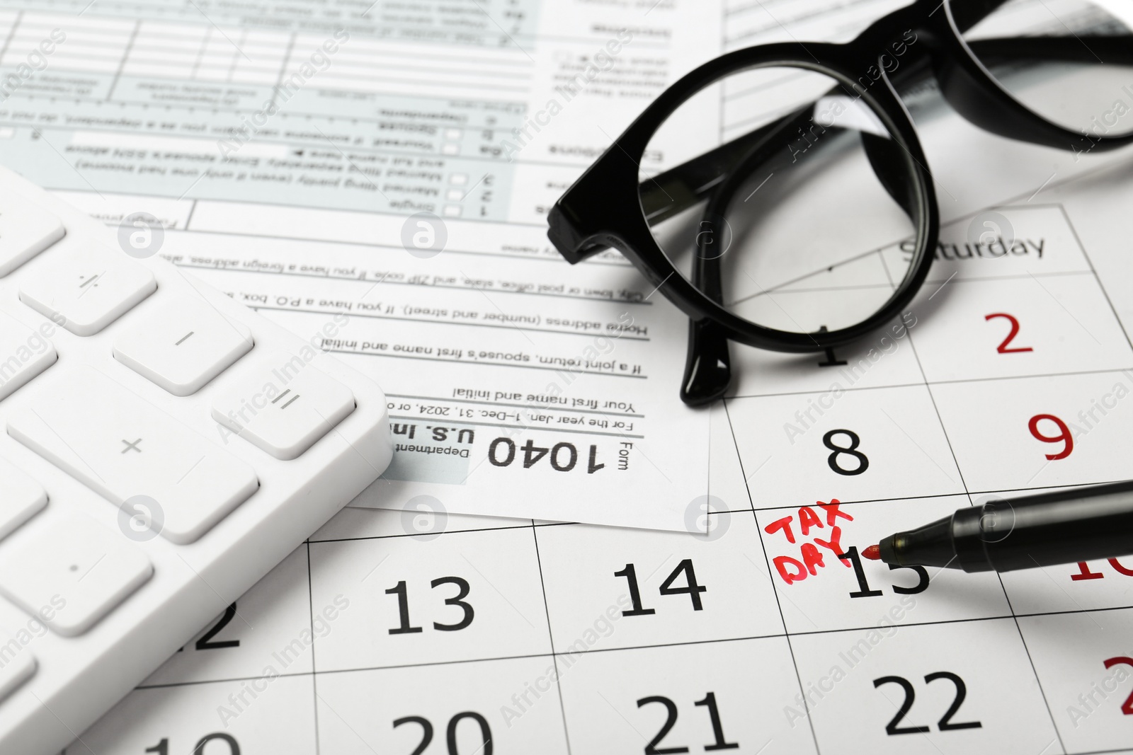 Photo of Marking tax day in calendar, felt pen, documents, glasses and calculator, closeup