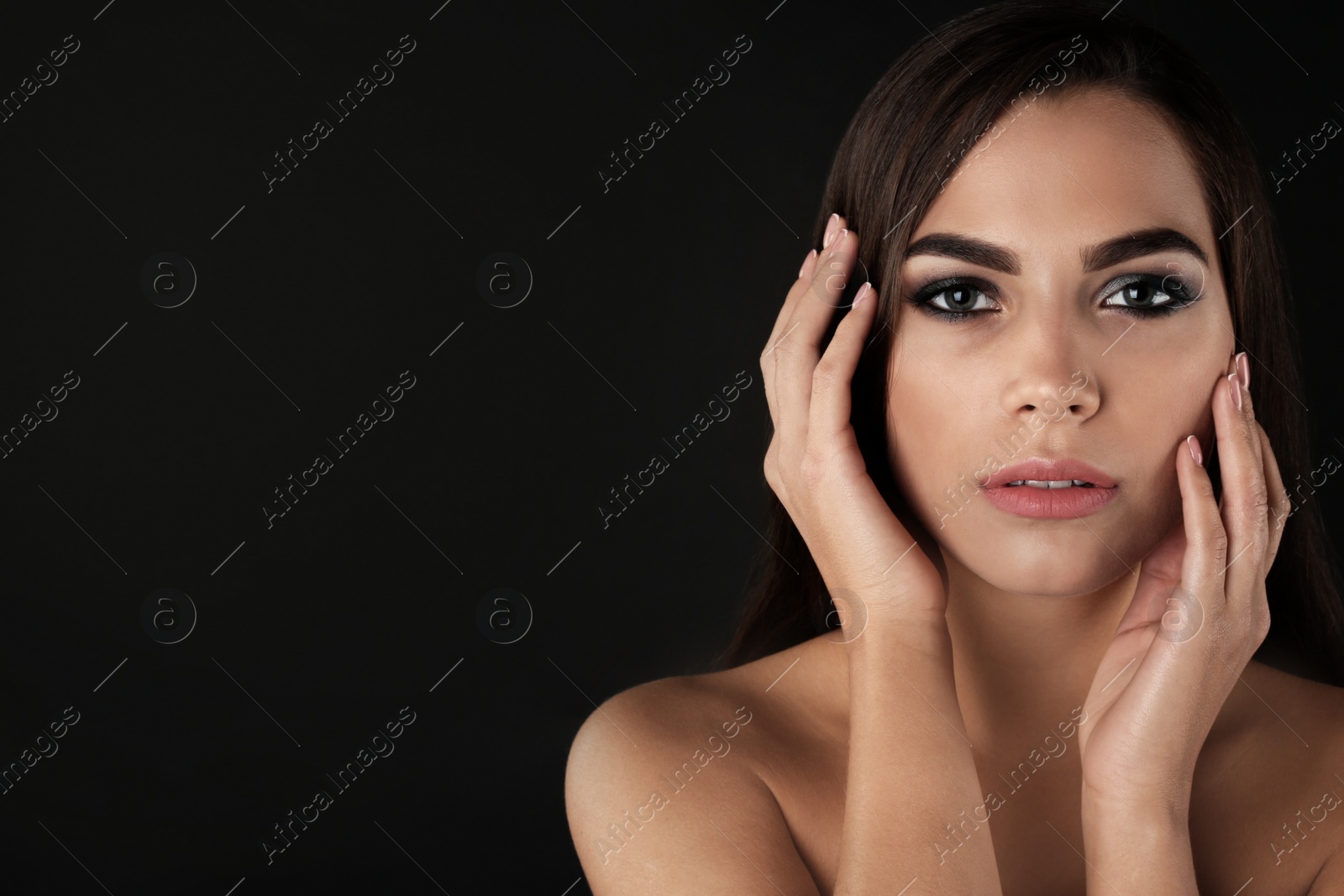 Photo of Portrait of beautiful woman with stylish makeup on dark background. Space for text