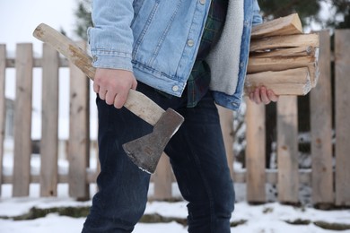Man with axe and wood outdoors on winter day, closeup