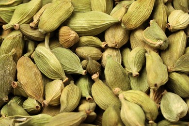 Photo of Pile of dry green cardamom pods as background, closeup
