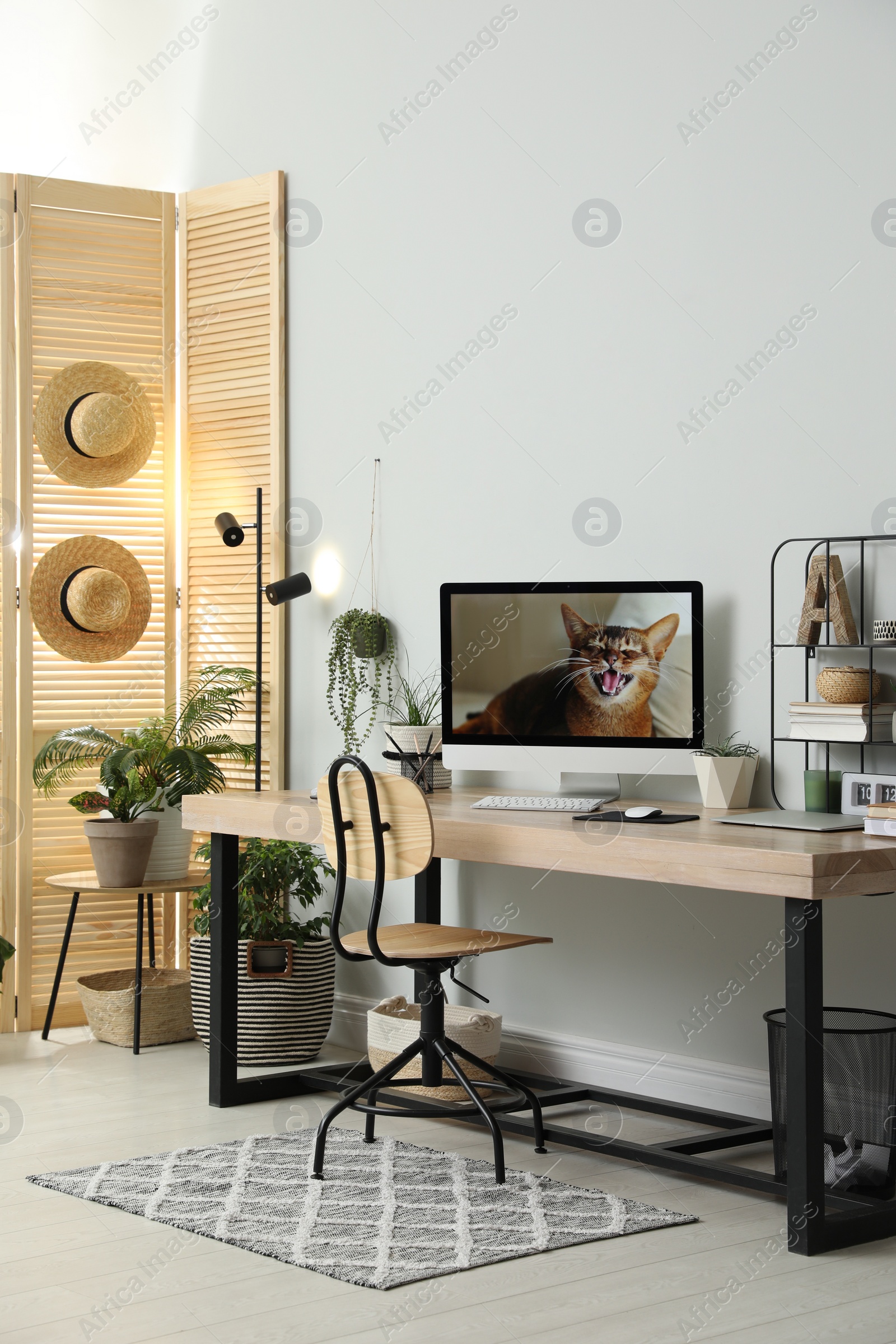 Photo of Comfortable workplace with computer in light room. Interior design