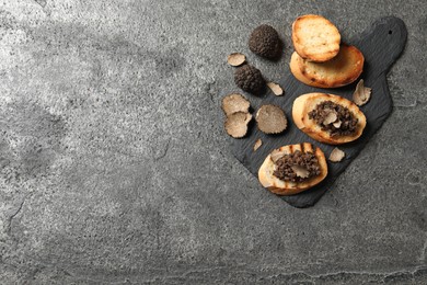 Photo of Delicious bruschettas with truffle sauce on grey table, flat lay. Space for text