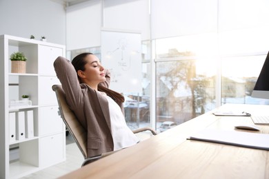 Photo of Young woman relaxing in office chair at workplace