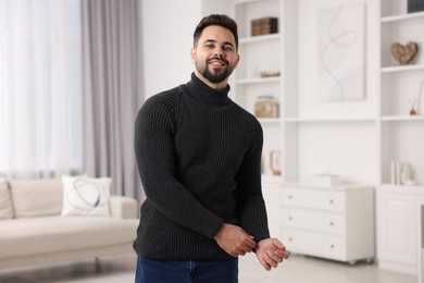 Happy man in stylish sweater at home