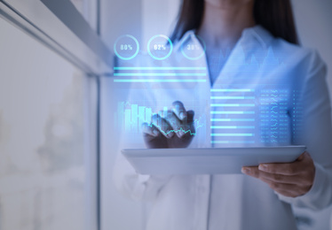 Image of Business analytics. Woman working with modern tablet in office, closeup