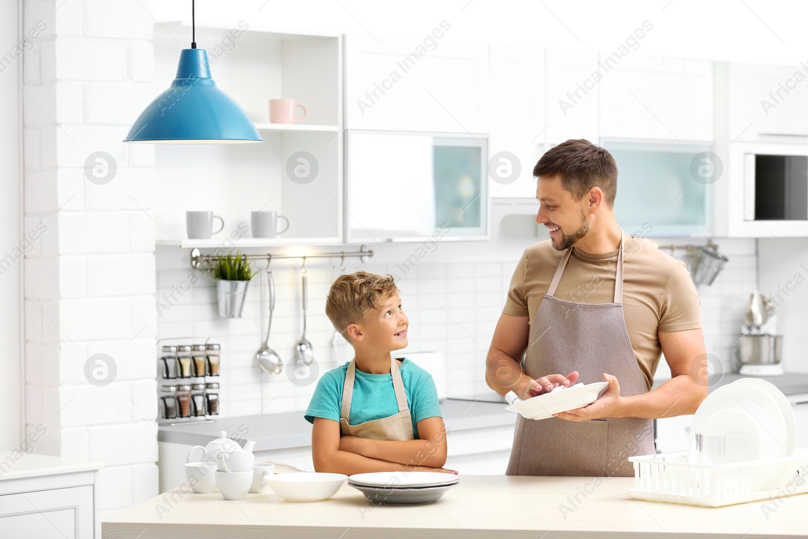 Photo of Dad and son wiping dishes in kitchen