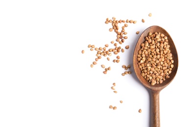 Spoon with uncooked buckwheat on white background, top view