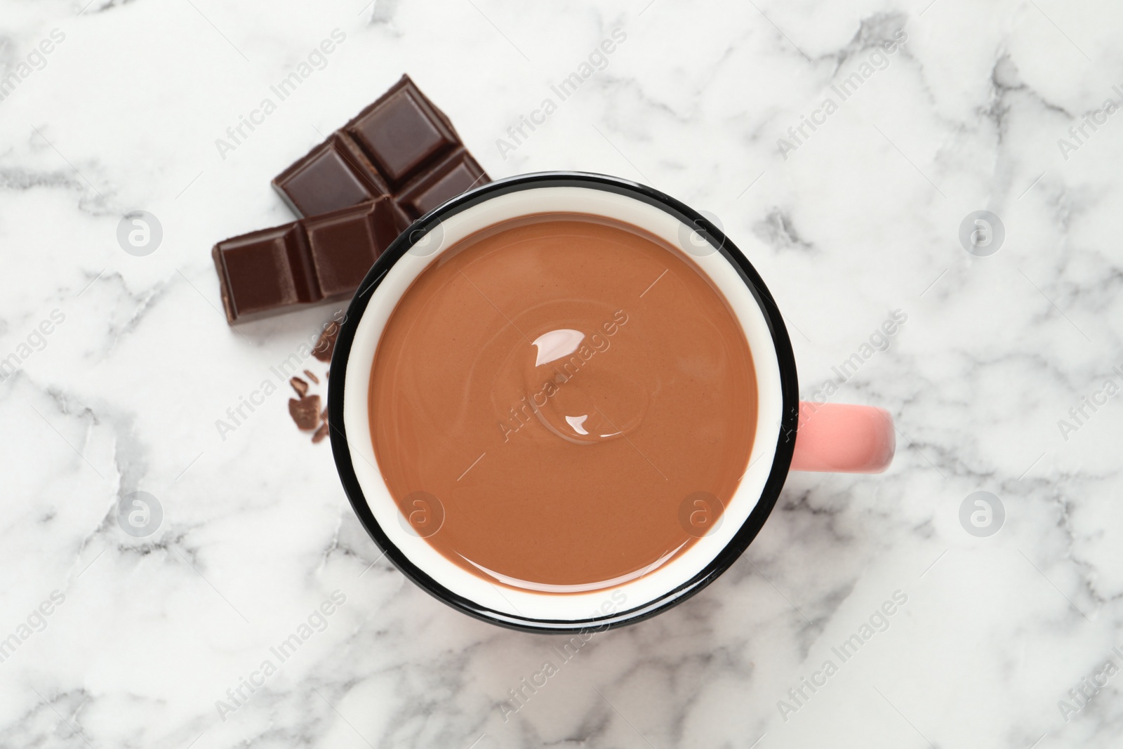 Photo of Yummy hot chocolate in mug on white marble table, flat lay