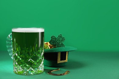 Photo of St. Patrick's day party. Green beer, leprechaun hat with gold, horseshoe and decorative clover leaf on green background