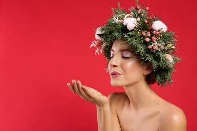 Photo of Young woman wearing wreath on red background