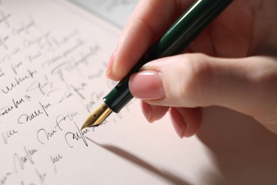 Photo of Woman writing letter with fountain pen, closeup