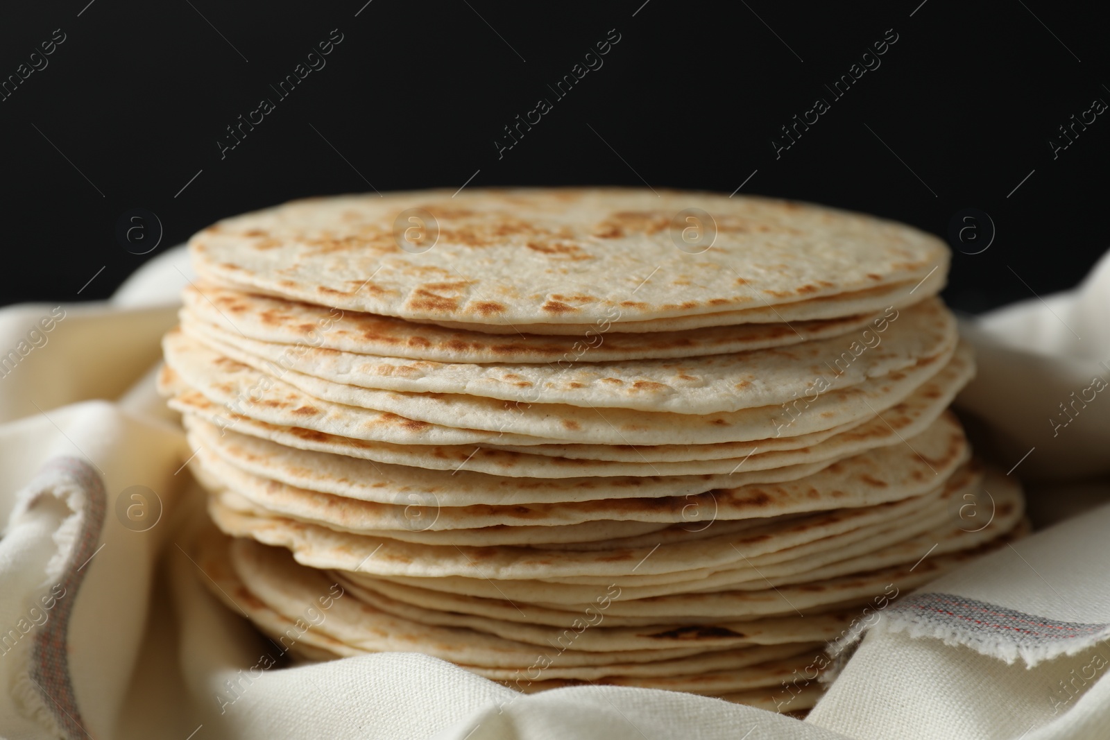 Photo of Stack of tasty homemade tortillas on table