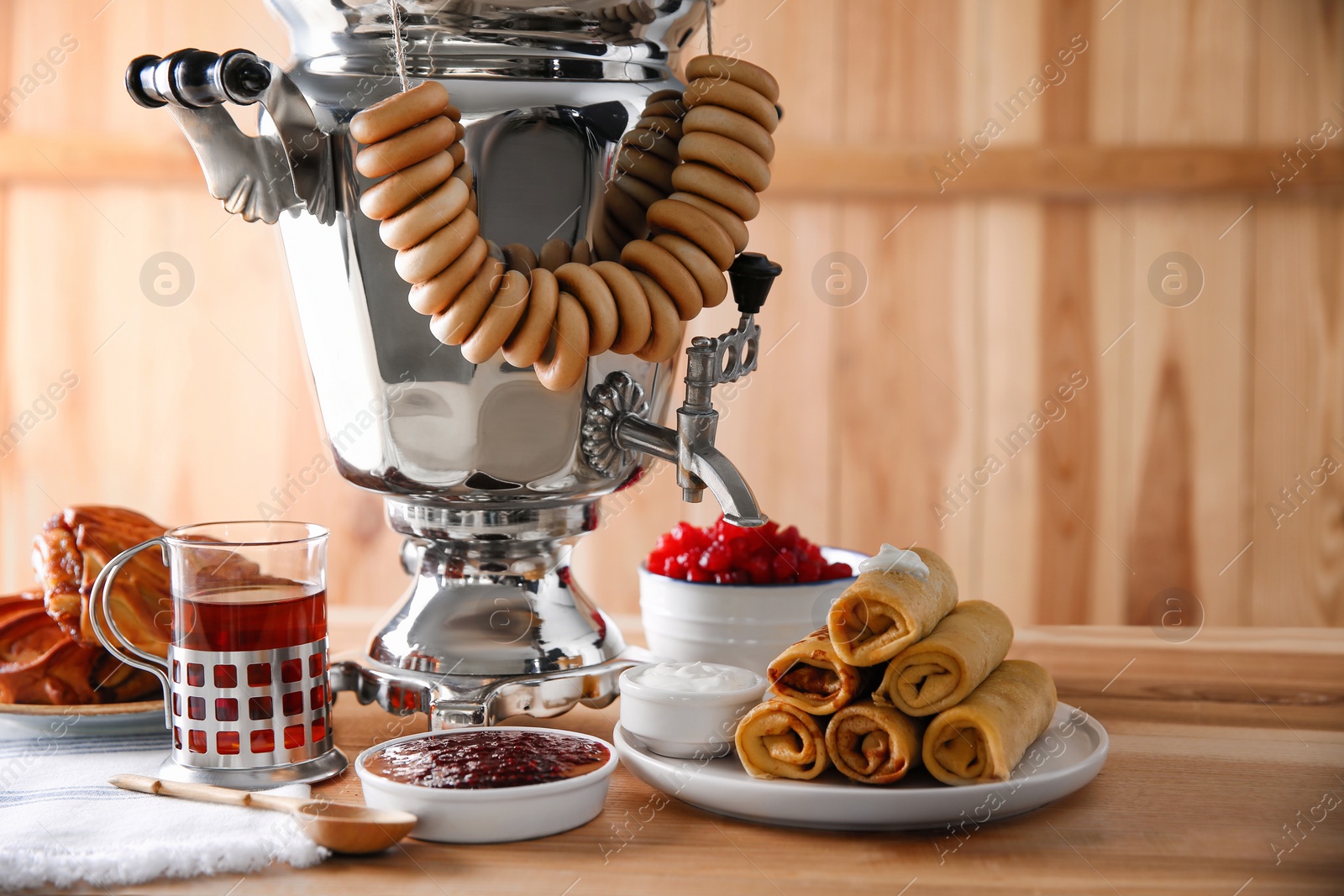 Photo of Traditional Russian samovar and treats on wooden table