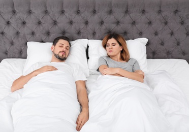 Photo of Couple with relationship problems in bed at home