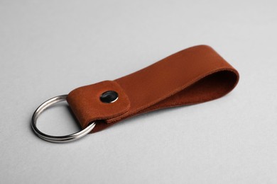 Photo of Leather keychain with Ukrainian coat of arms on light grey background, closeup