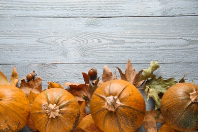 Photo of Ripe pumpkins on wooden background, flat lay with space for text. Holiday decoration