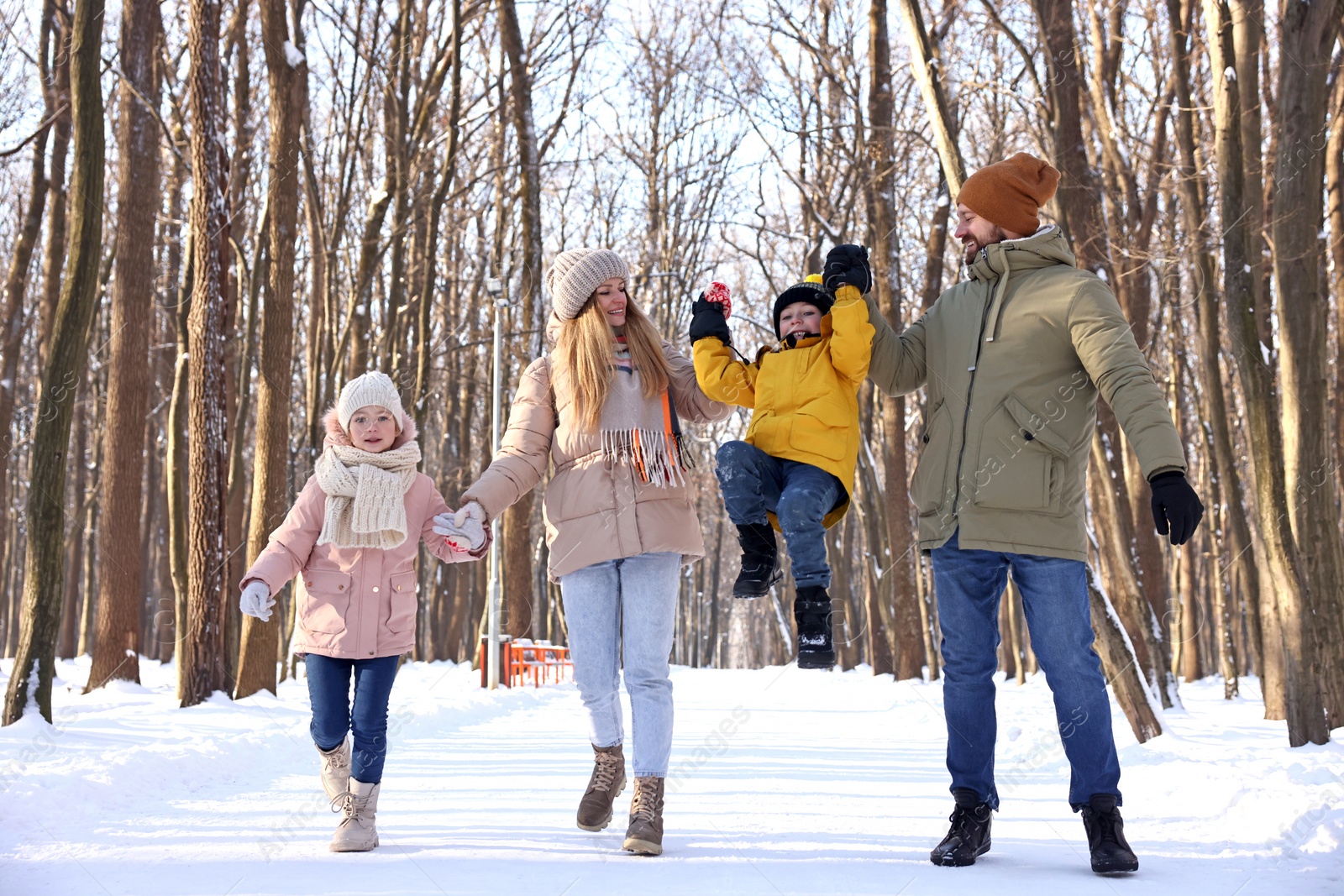 Photo of Happy family walking in sunny snowy forest