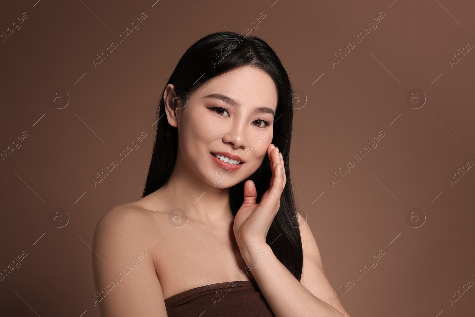 Photo of Portrait of beautiful woman on brown background