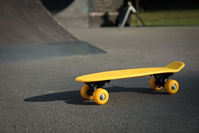 Photo of Modern yellow skateboard on asphalt road outdoors