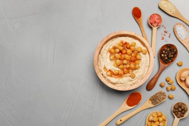 Photo of Delicious hummus with chickpeas and different ingredients on light grey table, flat lay. Space for text