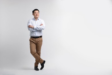 Photo of Full length portrait of happy man on light background. Space for text