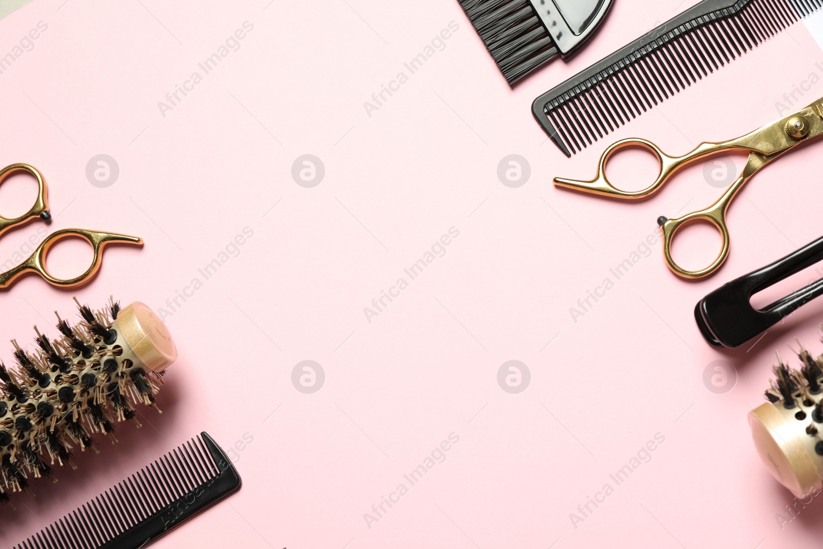 Photo of Professional hair dresser tools on pink background, flat lay. Space for text