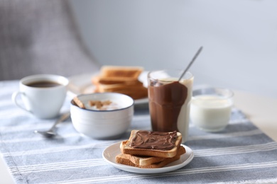 Photo of Delicious breakfast with toasts and chocolate paste on table