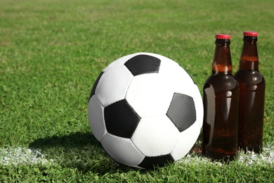 Photo of Soccer ball with beverage on green football field grass